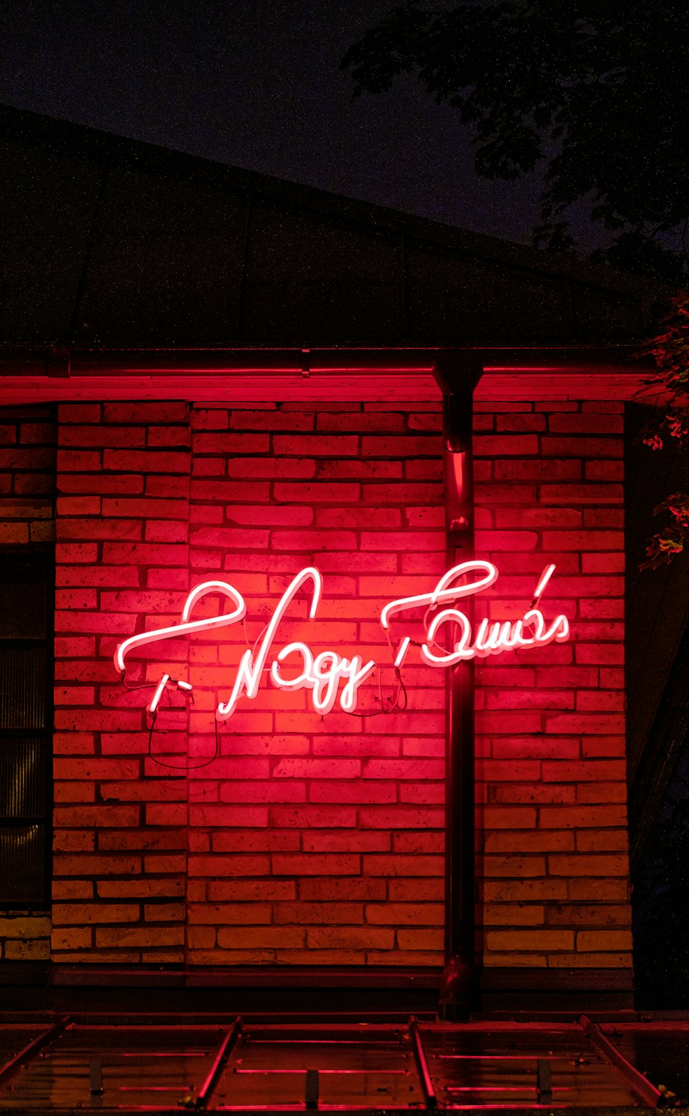 a brick building with a neon sign on it