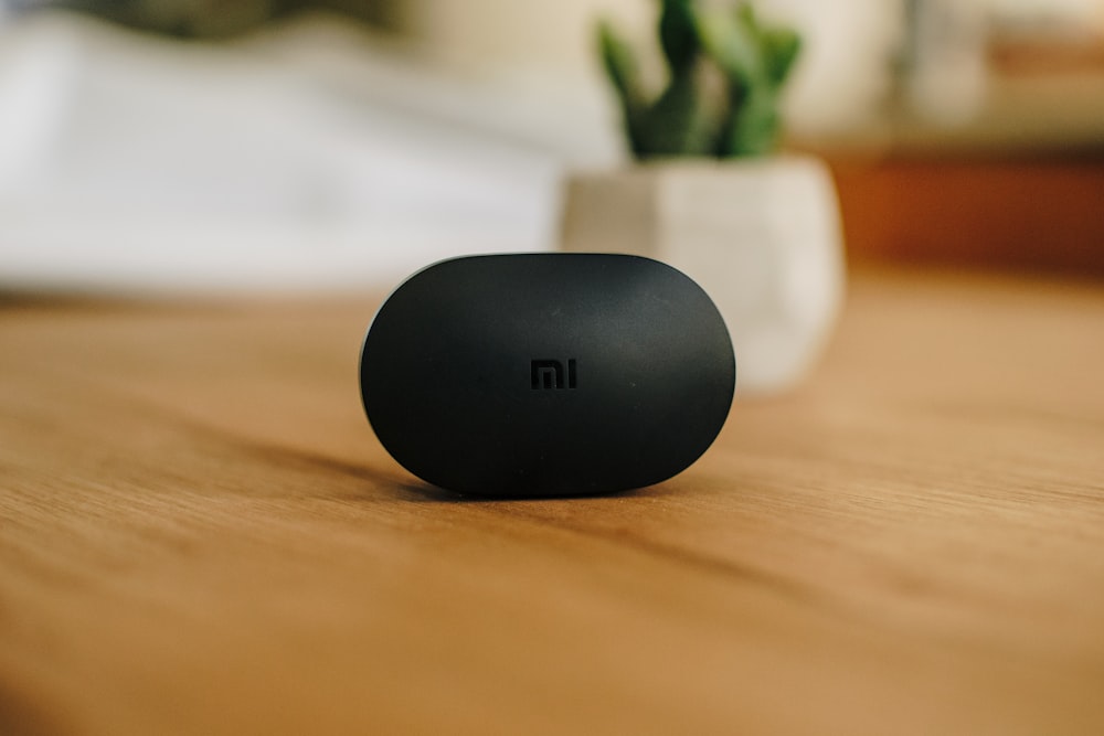 black round speaker on brown wooden table