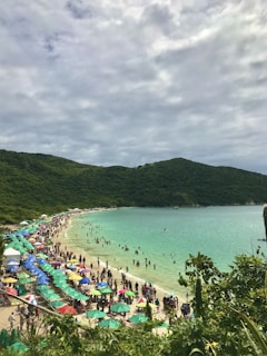 Crowded beach with colorful umbrellas and families enjoying the sun