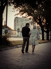 couple walking on sidewalk during daytime