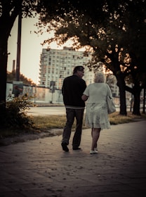 couple walking on sidewalk during daytime