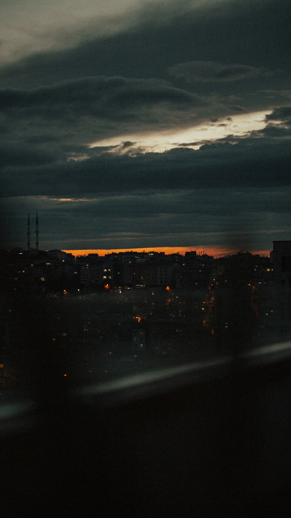 city skyline under cloudy sky during night time