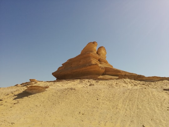 brown rock formation under blue sky during daytime in Fayoum Egypt