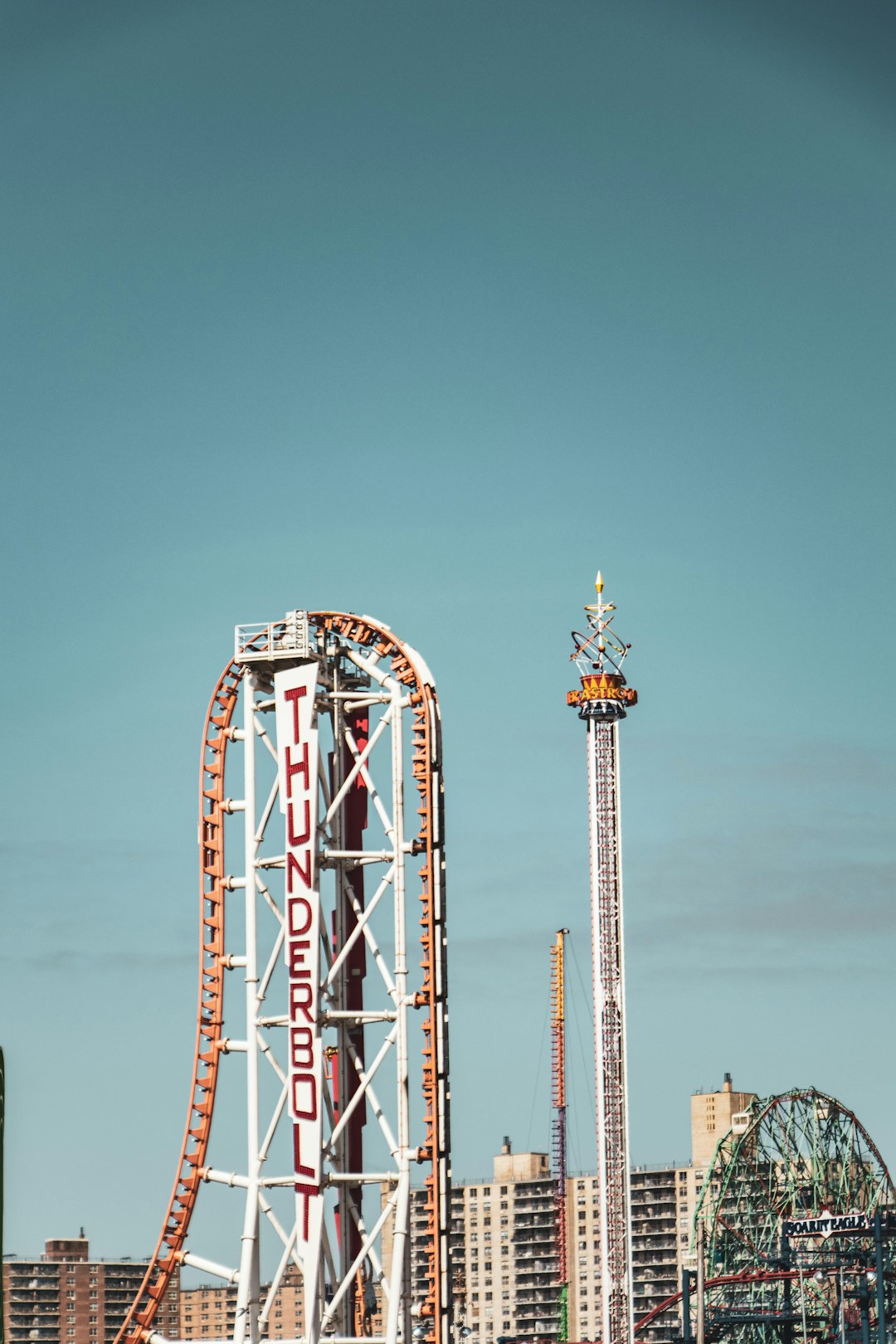 red and white ferris wheel under blue sky during daytime