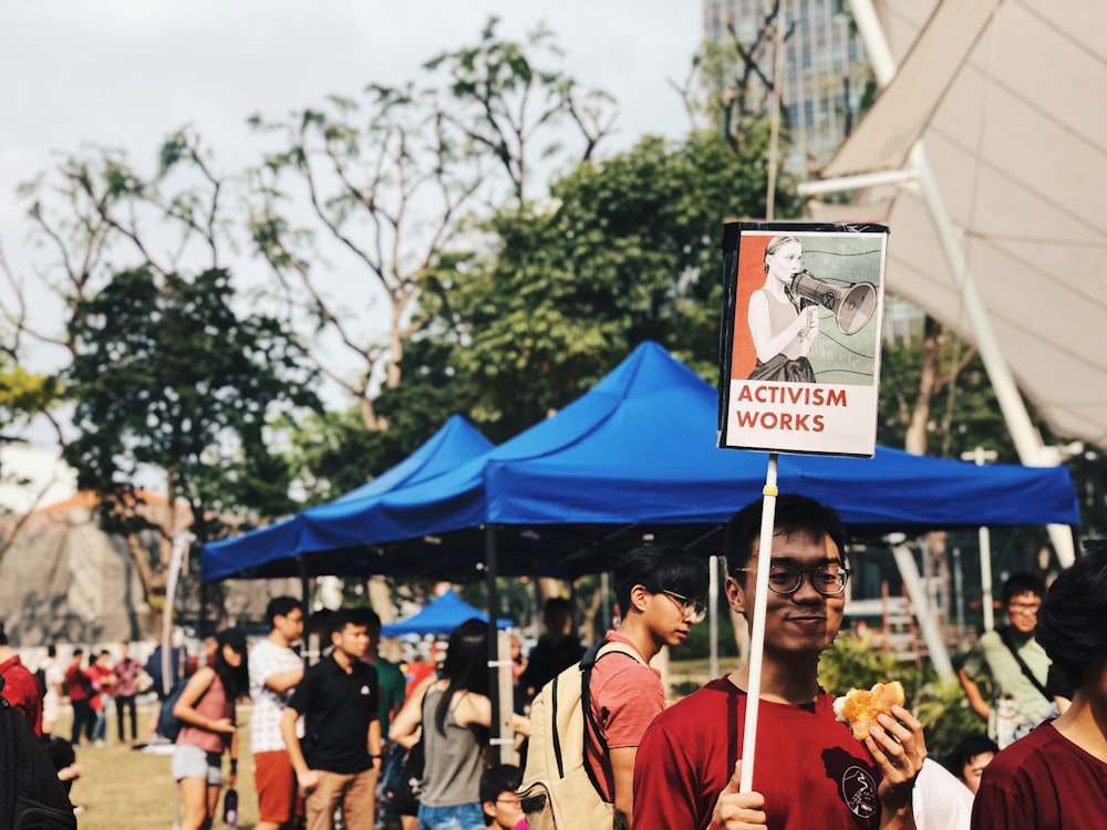 people holding blue and white banner during daytime