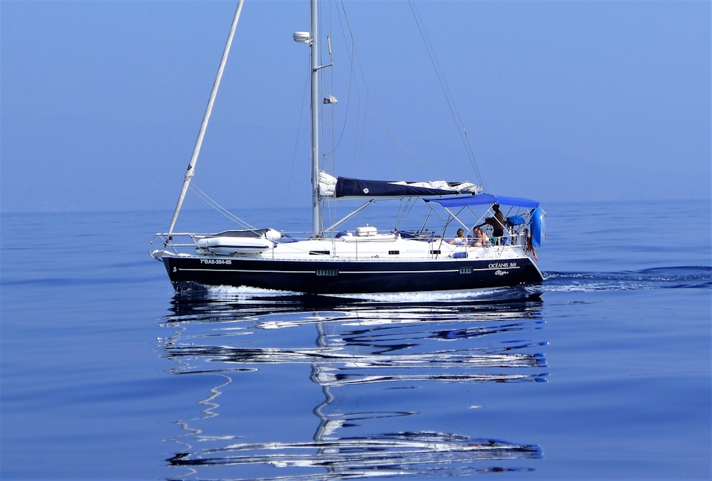 weißes und blaues Boot auf blauem Meer tagsüber