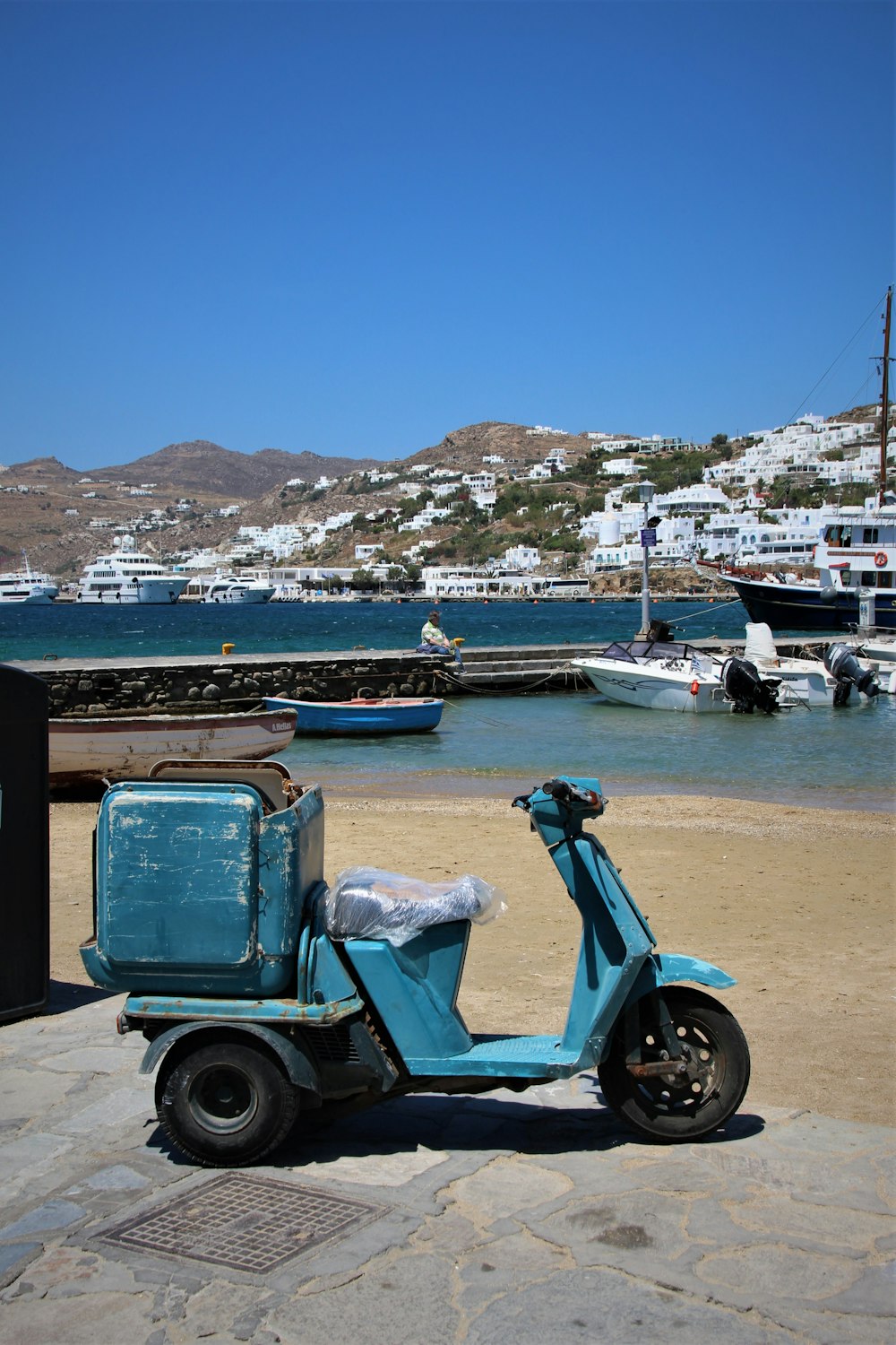 blue and black motor scooter parked near body of water during daytime photo  – Free Mýkonos Image on Unsplash