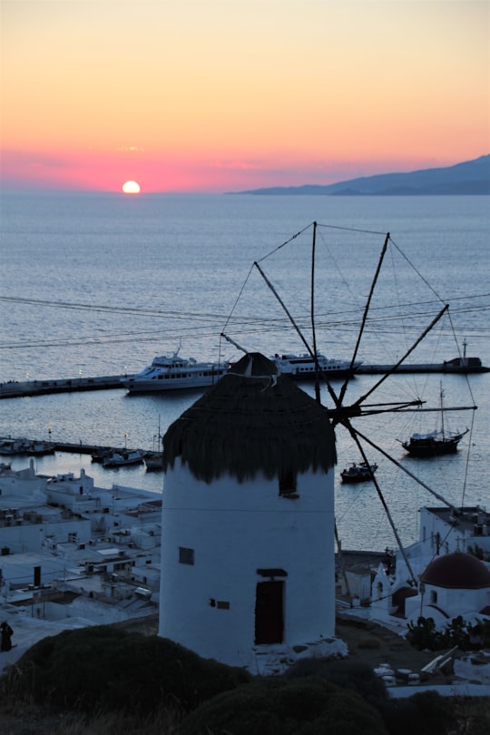 white and brown concrete building near body of water during sunset in Mýkonos Greece