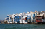 White and blue medina walls of Asilah stretching along the Atlantic Ocean coastline in bright sunlight.