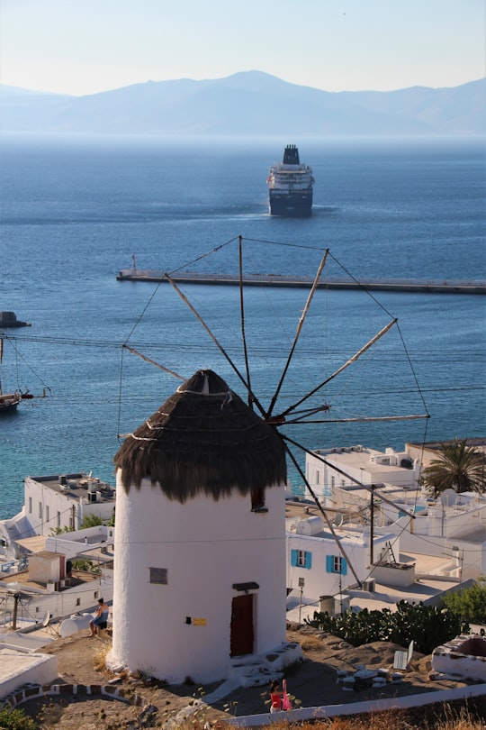 white and brown concrete building near body of water during daytime in Mýkonos Greece