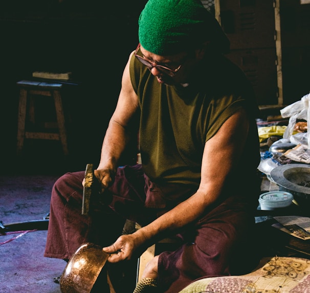 man in brown crew neck t-shirt and green knit cap sitting on floor