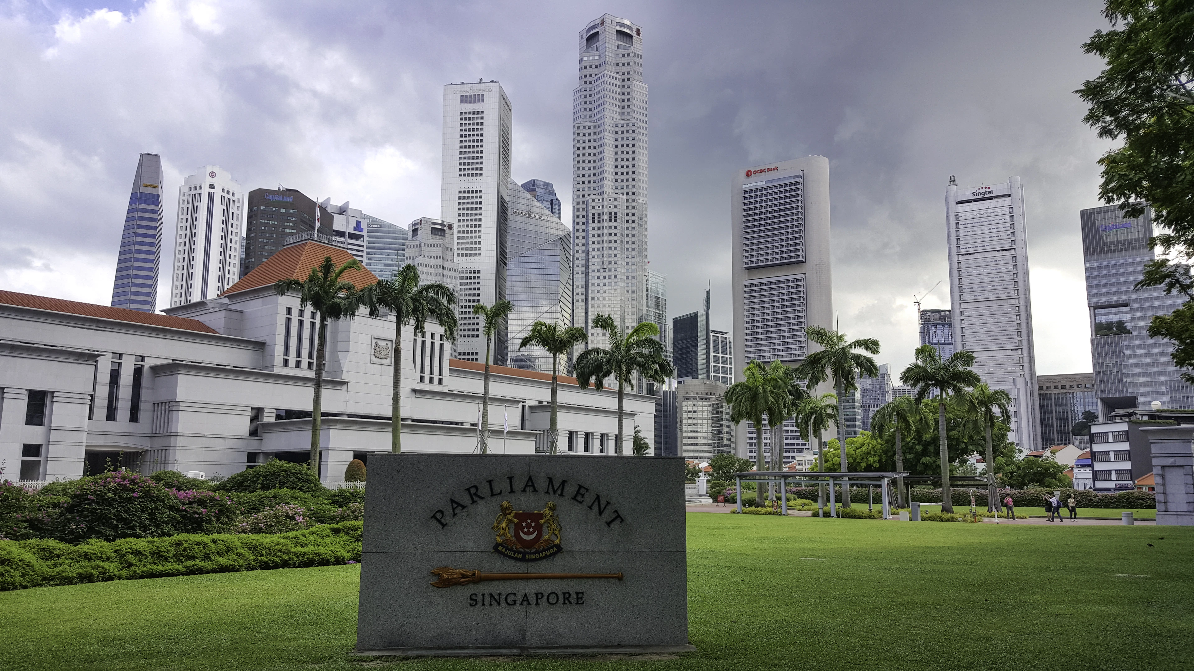 Singapore's Parliament House on its lawn with the towers of the financial district rising behind