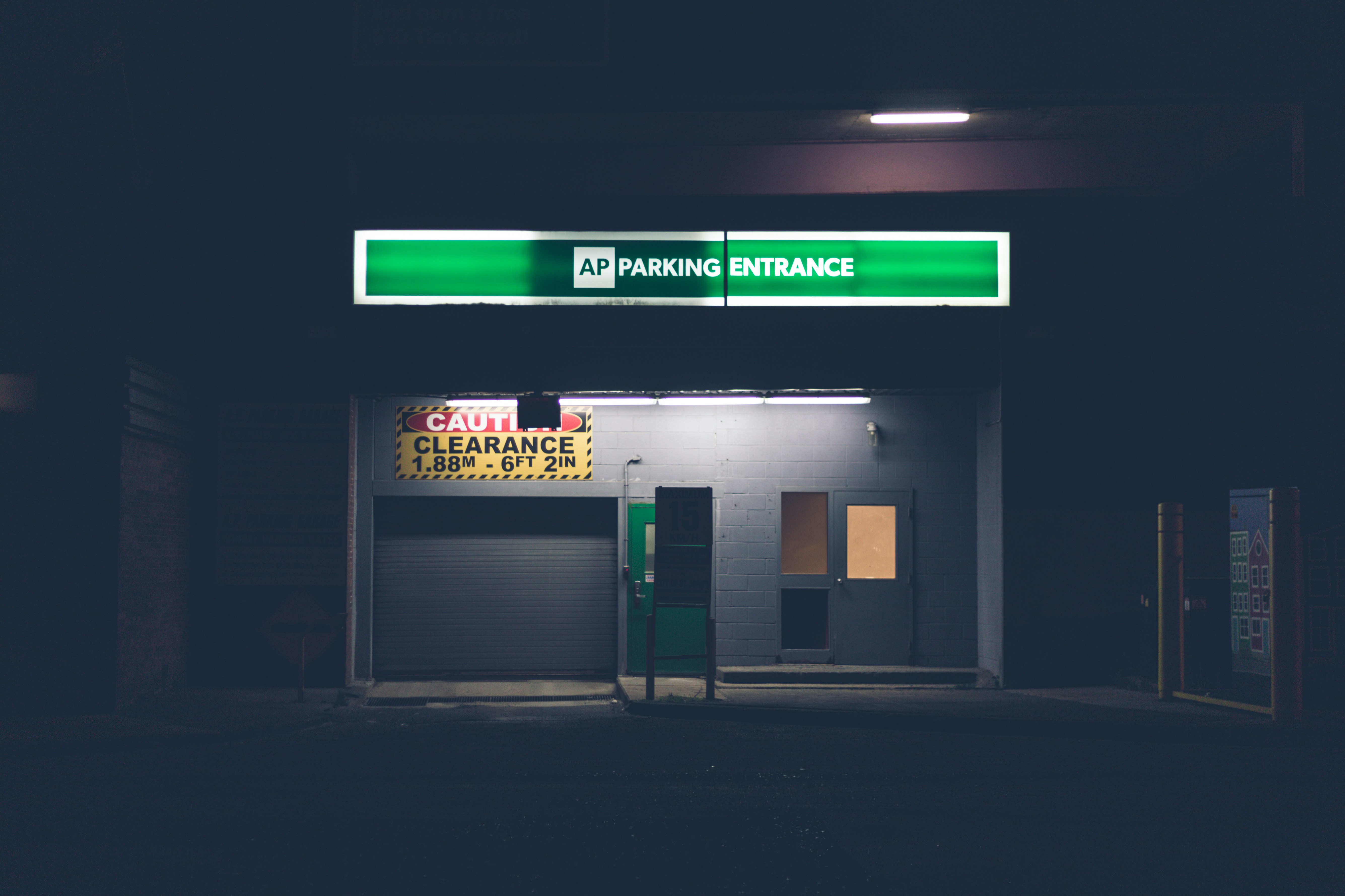 a parking entrance with a green sign above it