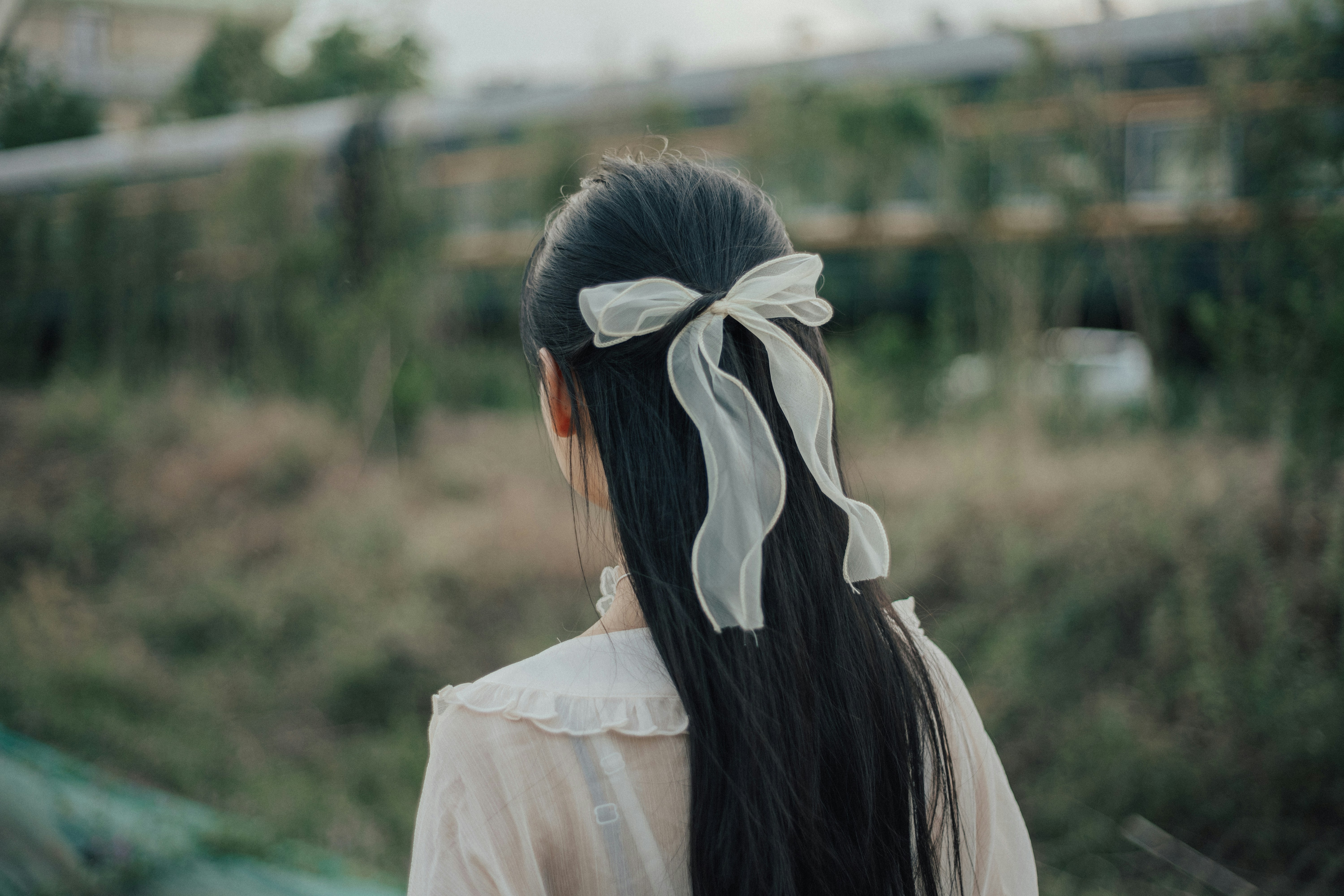 woman in white dress with white ribbon on head