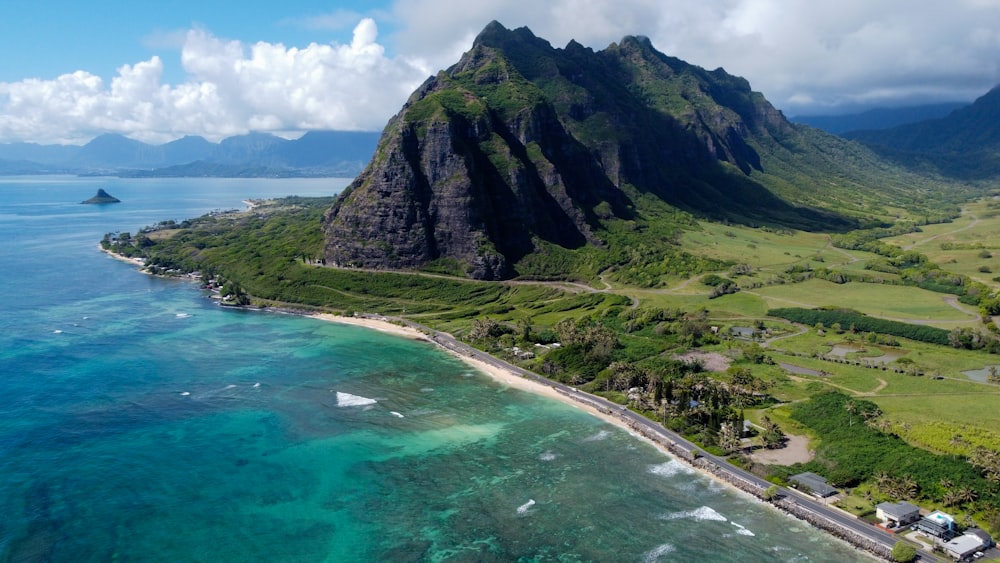 green and gray mountain beside body of water during daytime