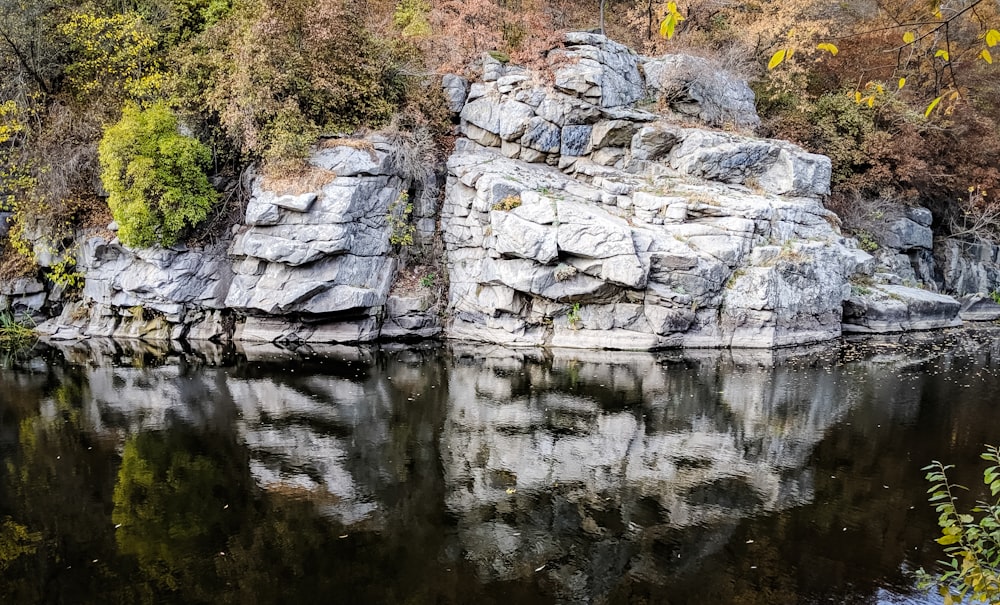 gray rock formation beside body of water during daytime