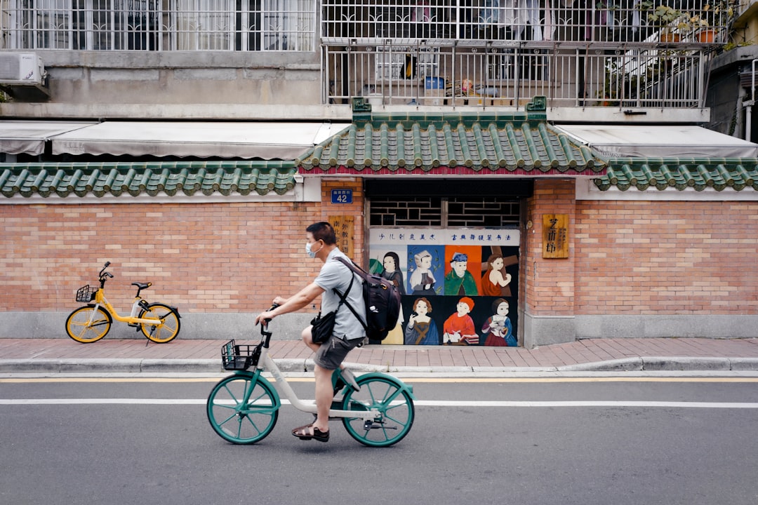 man in black jacket riding bicycle on road during daytime