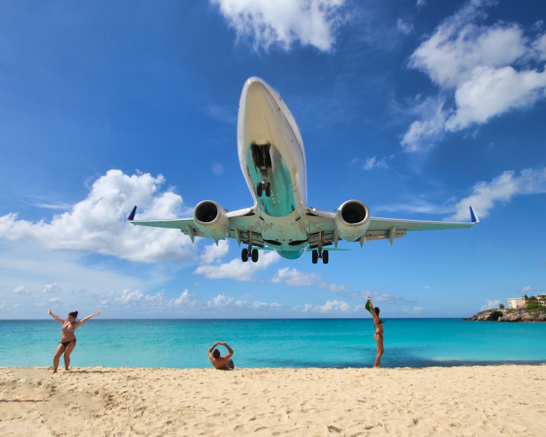 white airplane on white sand near body of water during daytime