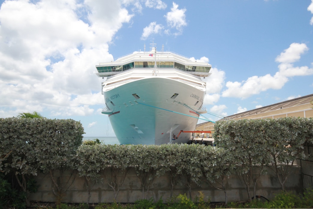 A friendly travel agent assisting a couple with cruise booking options at a bright, welcoming office.