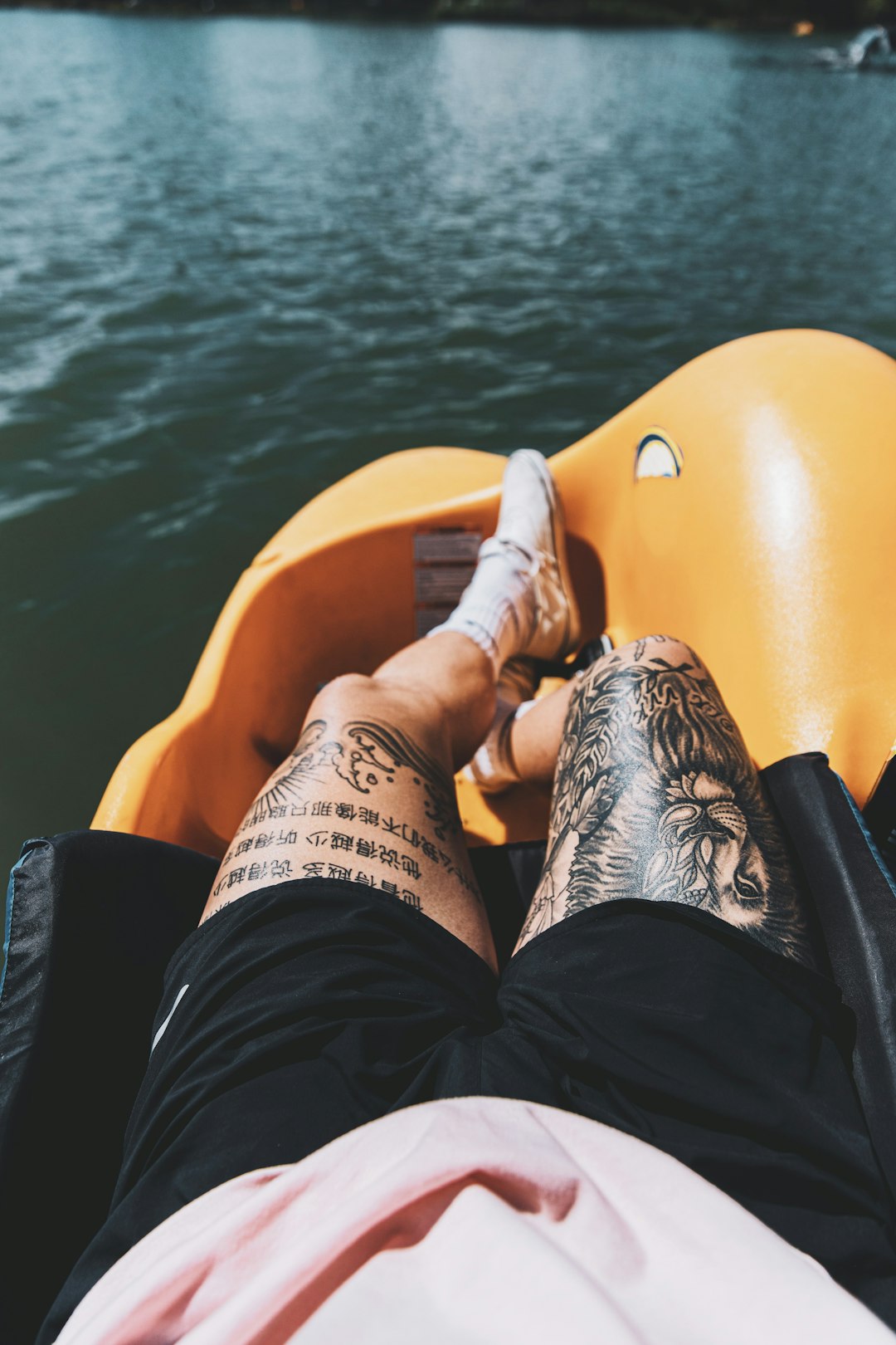 person in black shorts lying on yellow kayak