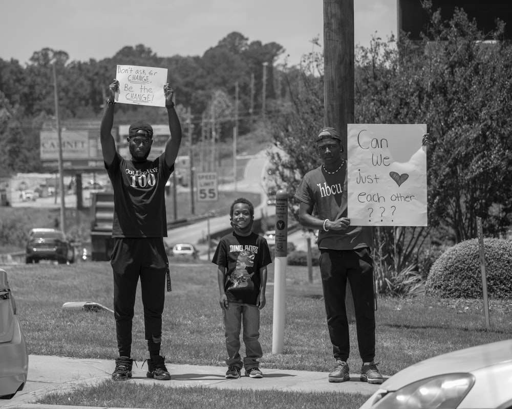 grayscale photo of man in black t-shirt and pants holding basketball hoop