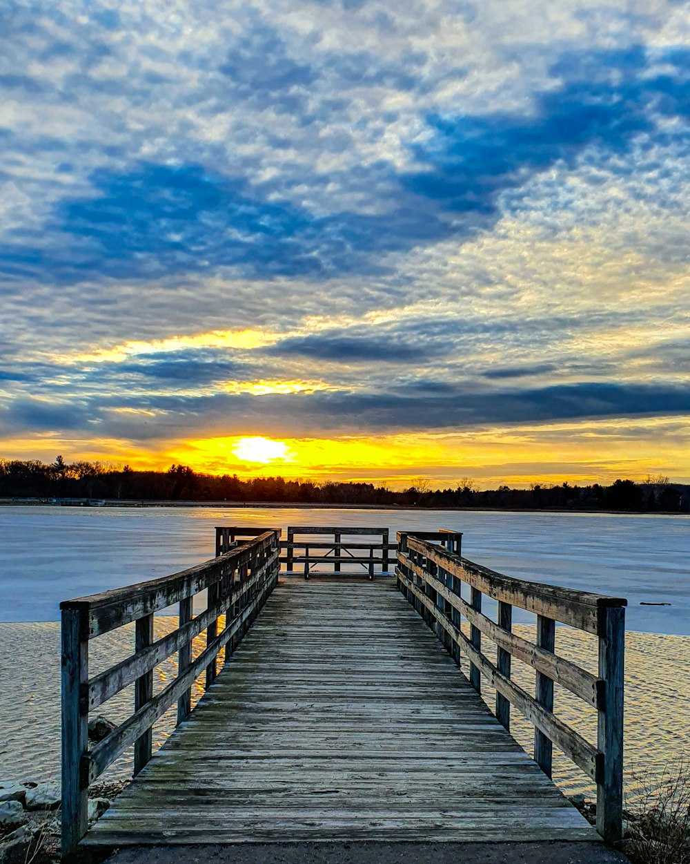 brown wooden dock on sea during sunset