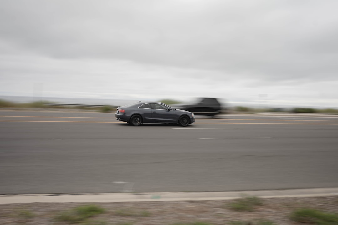 black sedan on gray asphalt road during daytime
