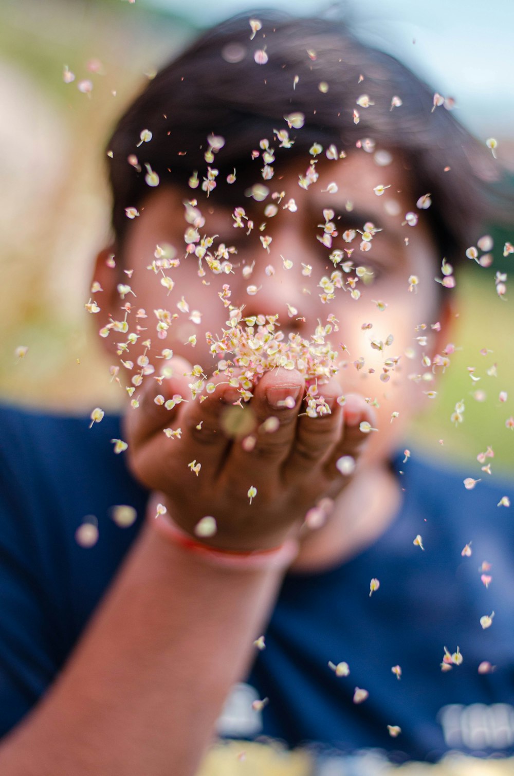 person in blue shirt blowing bubbles