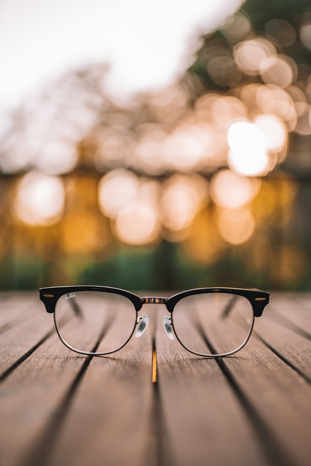 gafas de montura negra sobre mesa de madera marrón