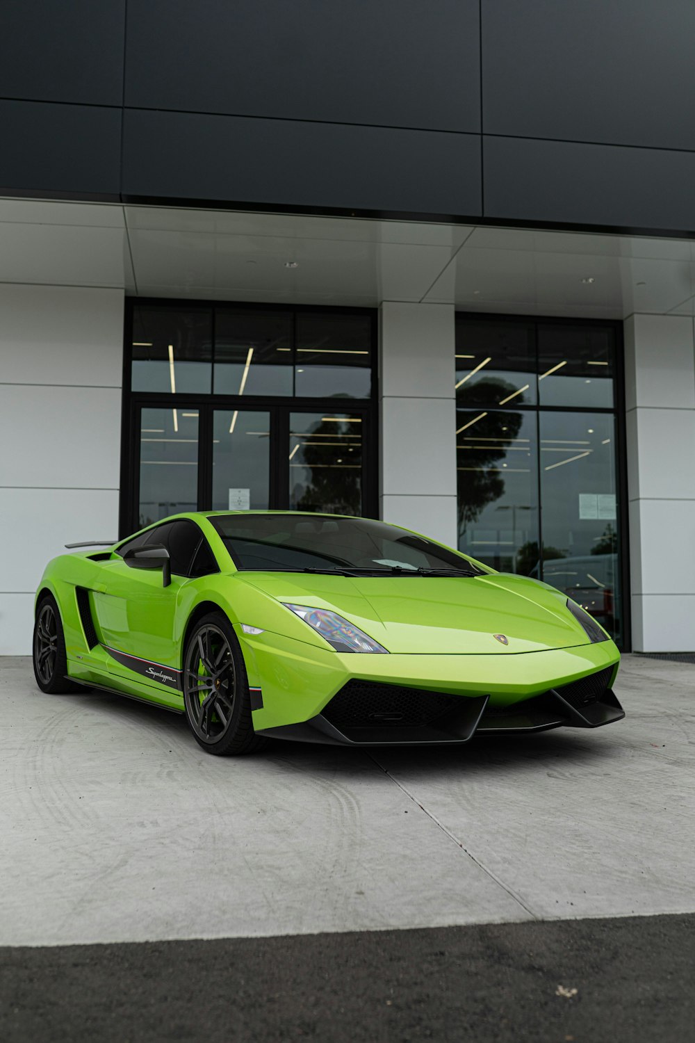 green lamborghini aventador parked in front of white building