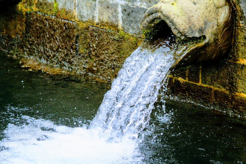 water falling from brown concrete wall