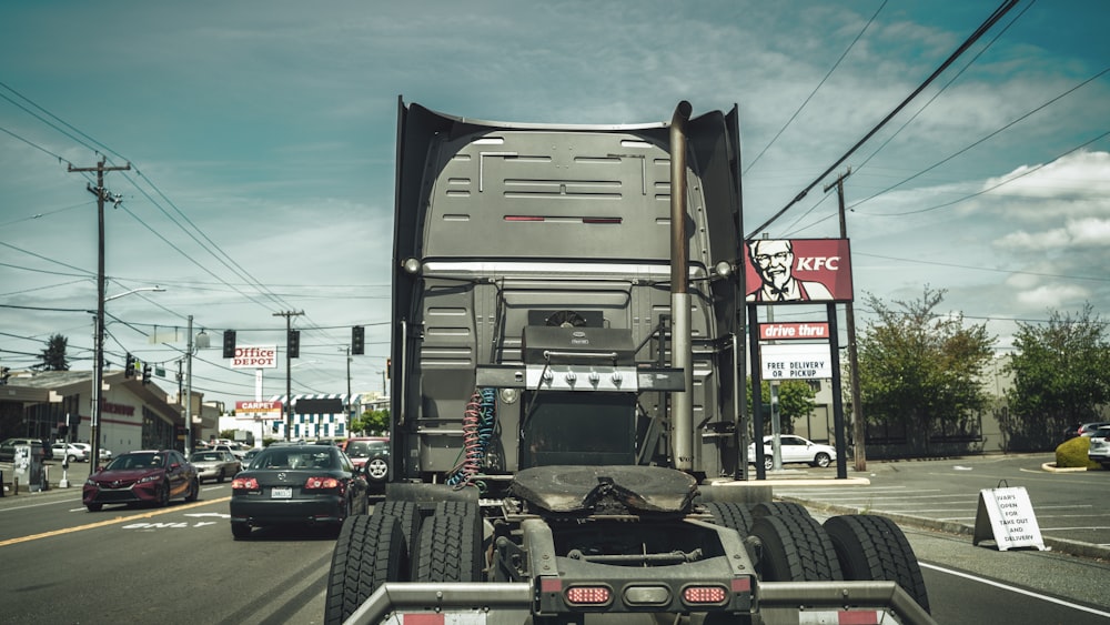 black car parked beside gray car during daytime