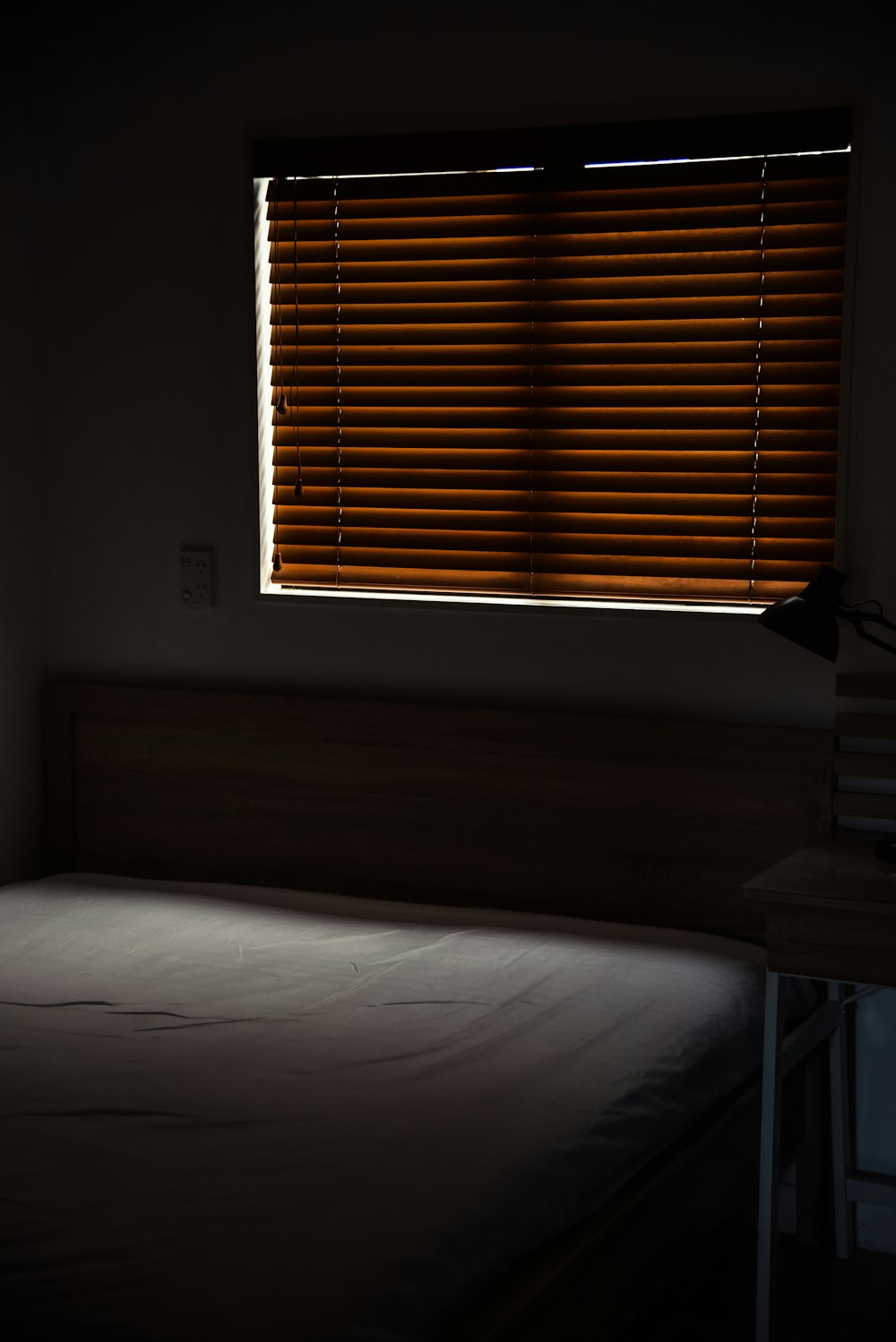 white bed linen near brown window blinds