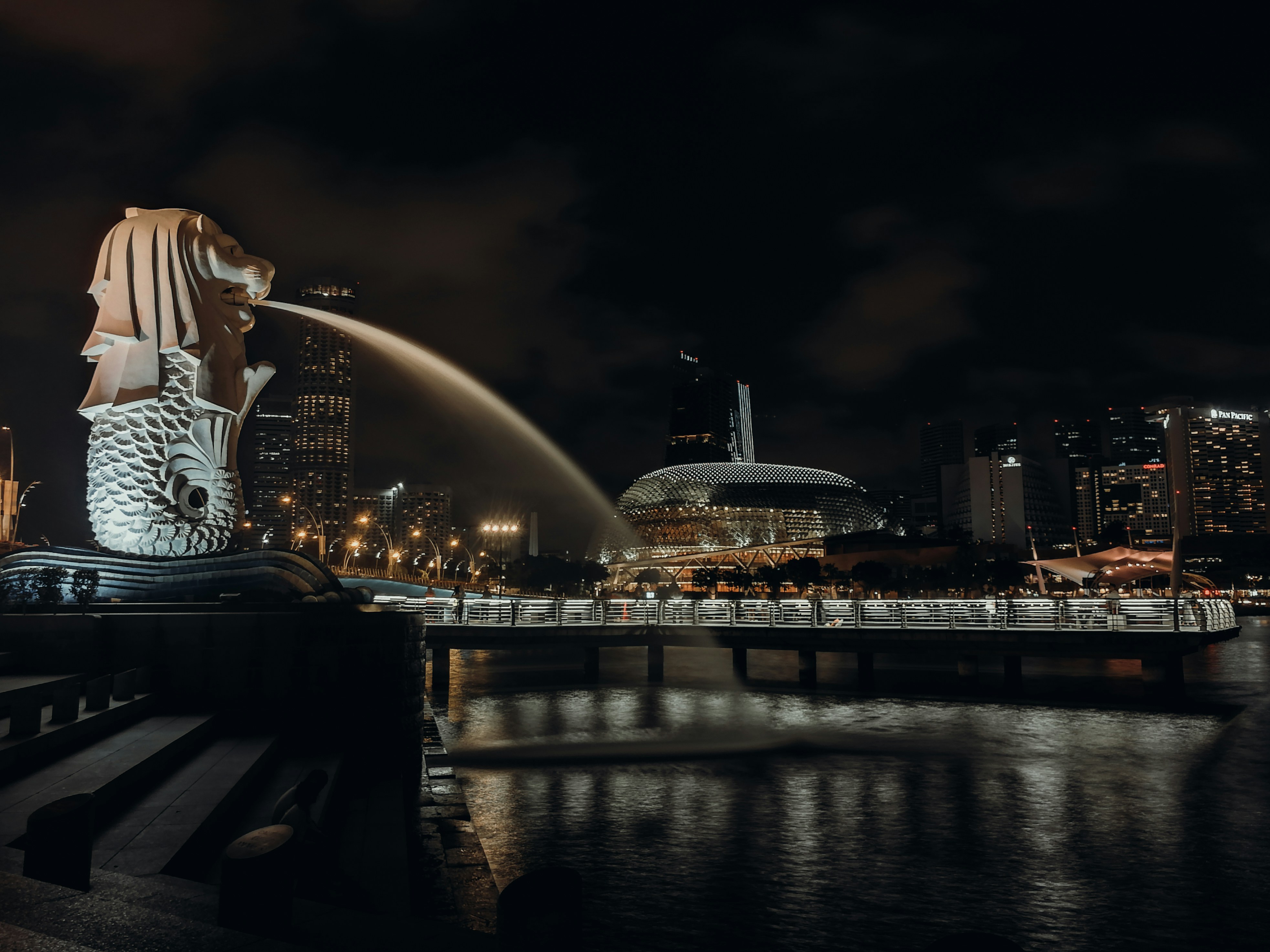 water fountain near city buildings during night time