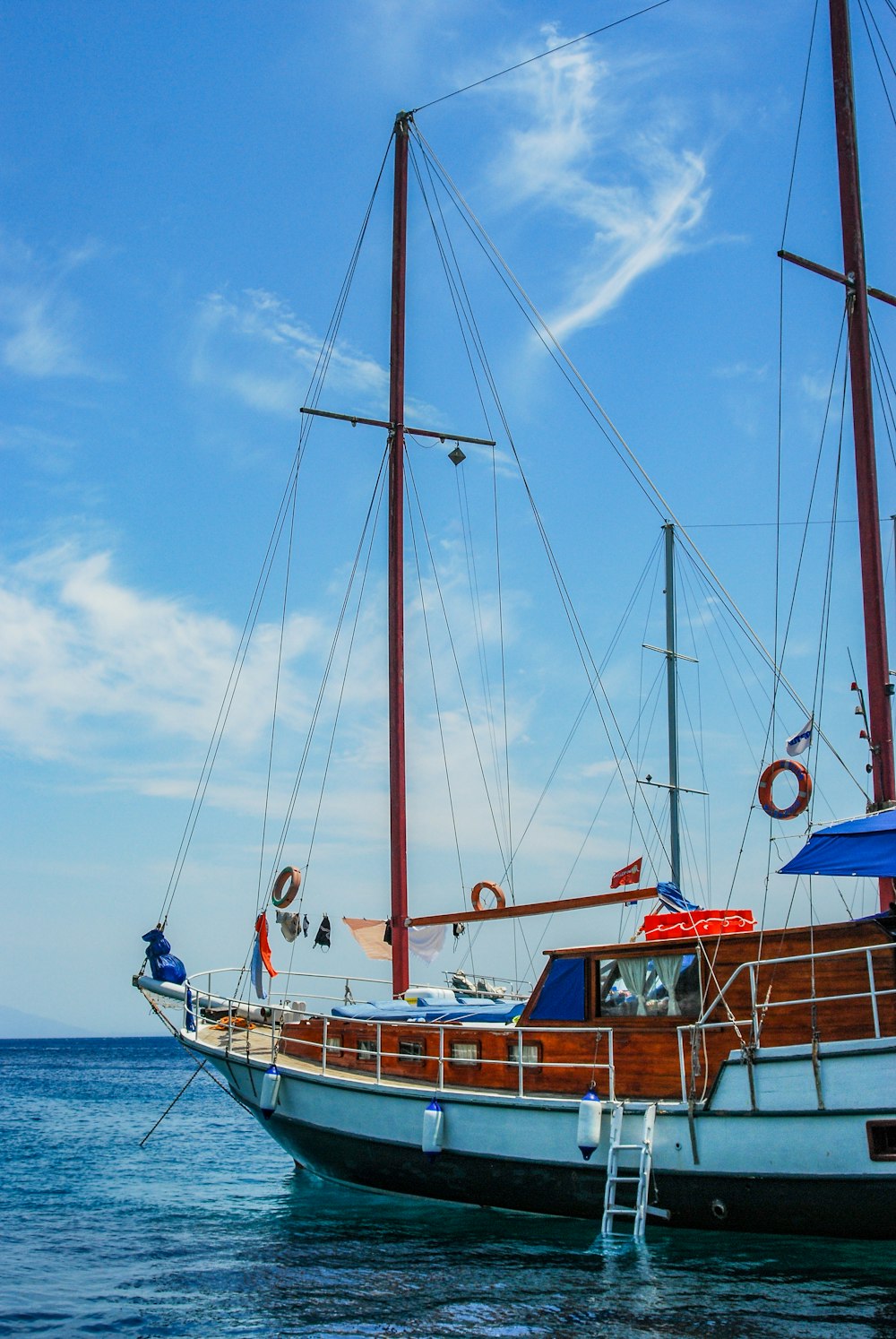 barco marrón y blanco en el mar bajo el cielo azul durante el día