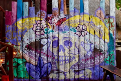 A colorful canvas artwork featuring day of the dead motifs and abstract elements.