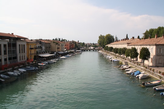 boats on river near buildings during daytime in Peschiera del Garda Italy
