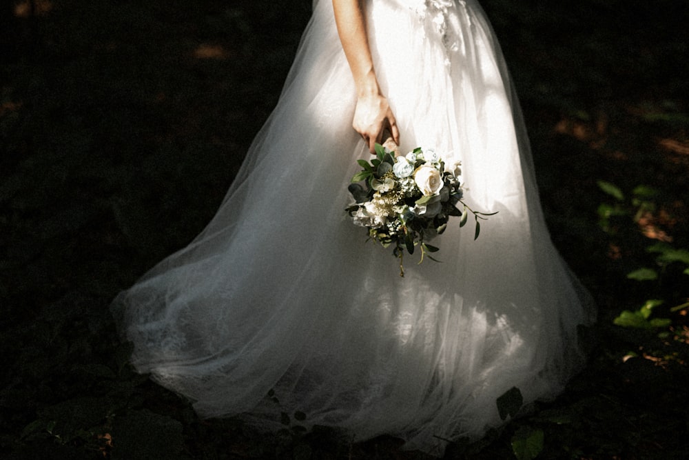 花束を持った白いウェディングドレスの女性