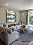 A modern living room featuring a large, elegant mirror with LED accents.
