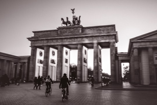 grayscale photo of people walking near building in Brandenburg Gate Germany