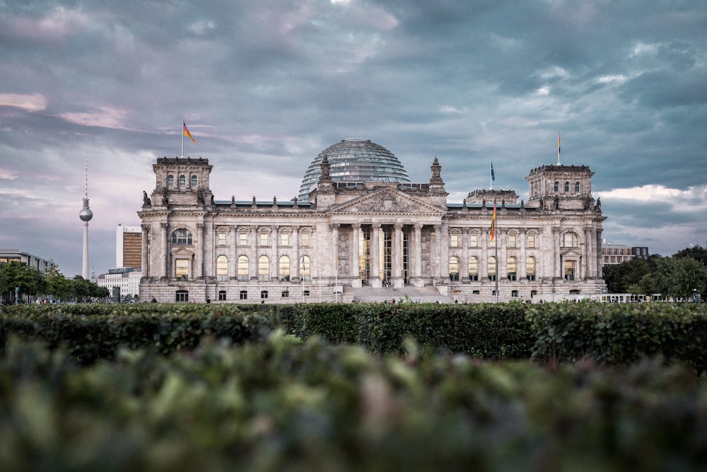 Weißes Betongebäude tagsüber unter bewölktem Himmel