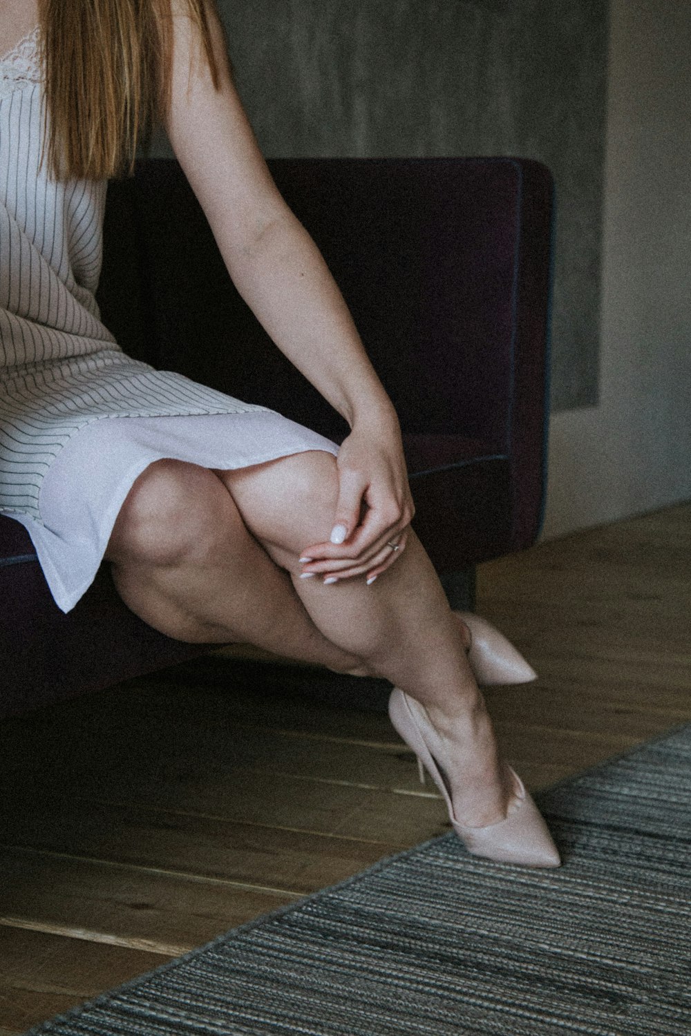 woman in black tank top and white skirt sitting on brown wooden floor