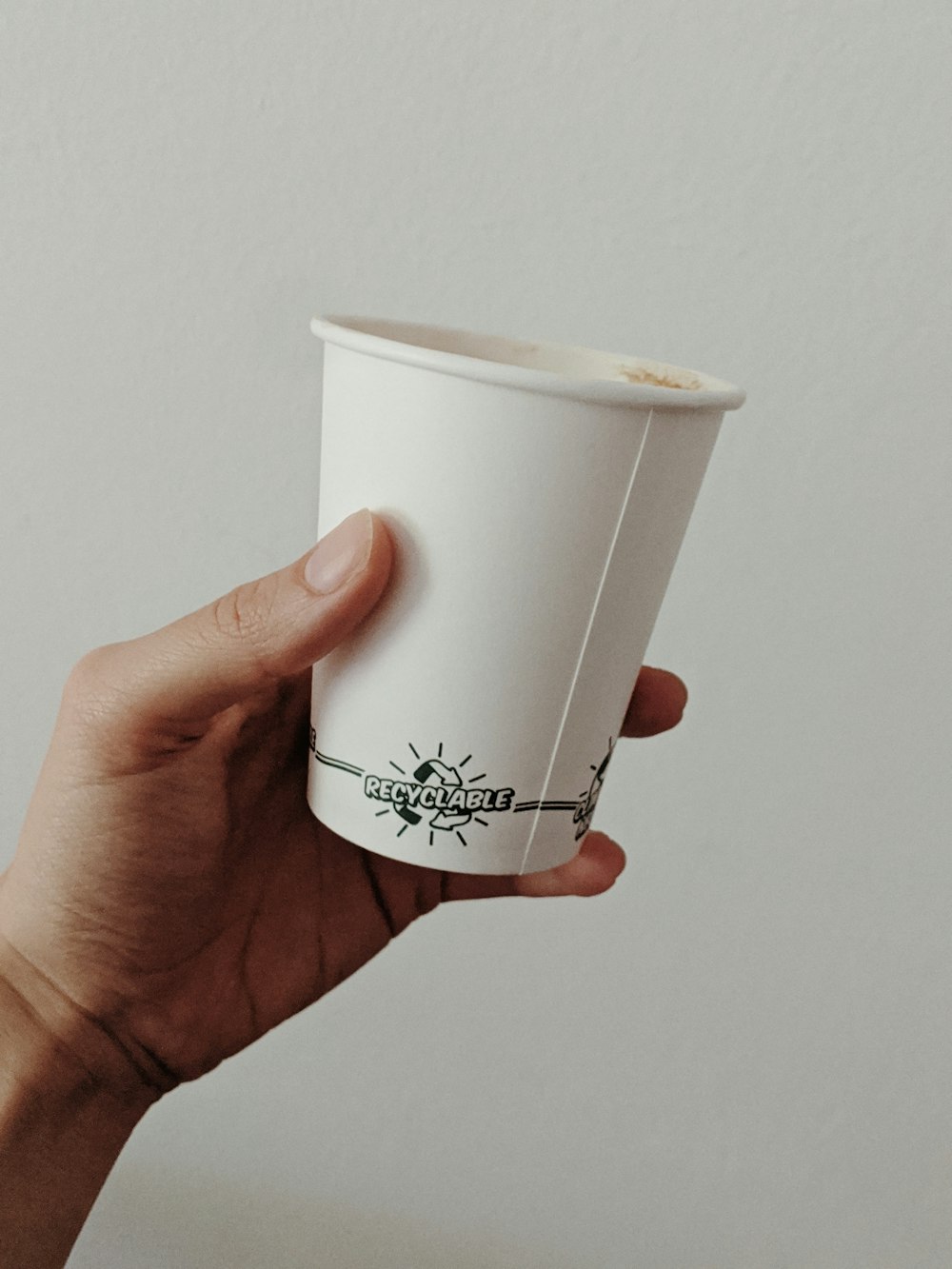 person holding white disposable cup