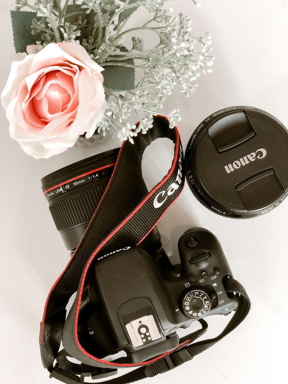black and red nikon dslr camera on white floral textile