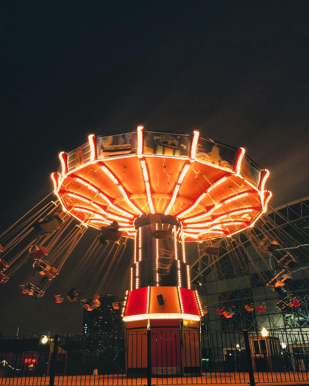 personnes marchant sur le parc d’attractions pendant la nuit