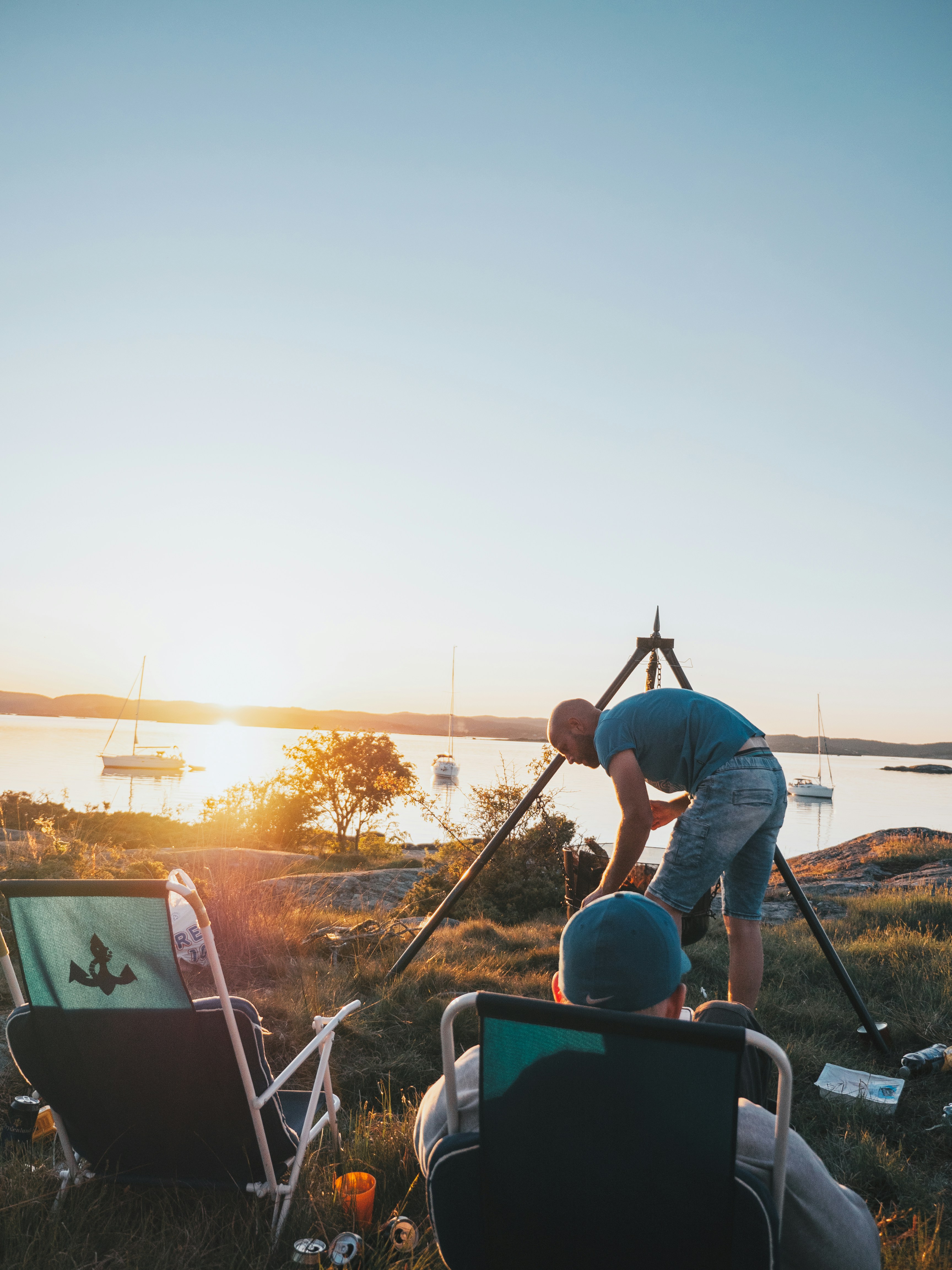 man in blue t-shirt and blue denim jeans holding brown wooden stick during daytime