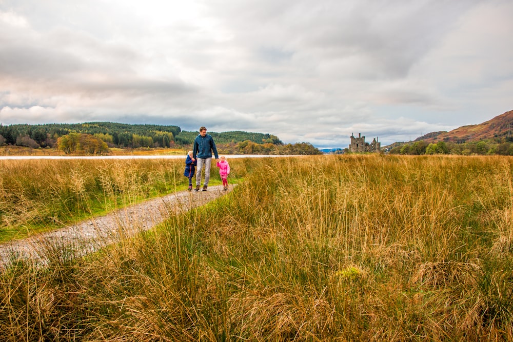 2 person walking on green grass field during daytime