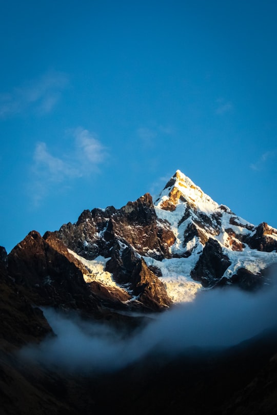 snow covered mountain under blue sky during daytime in Salcantay Peru