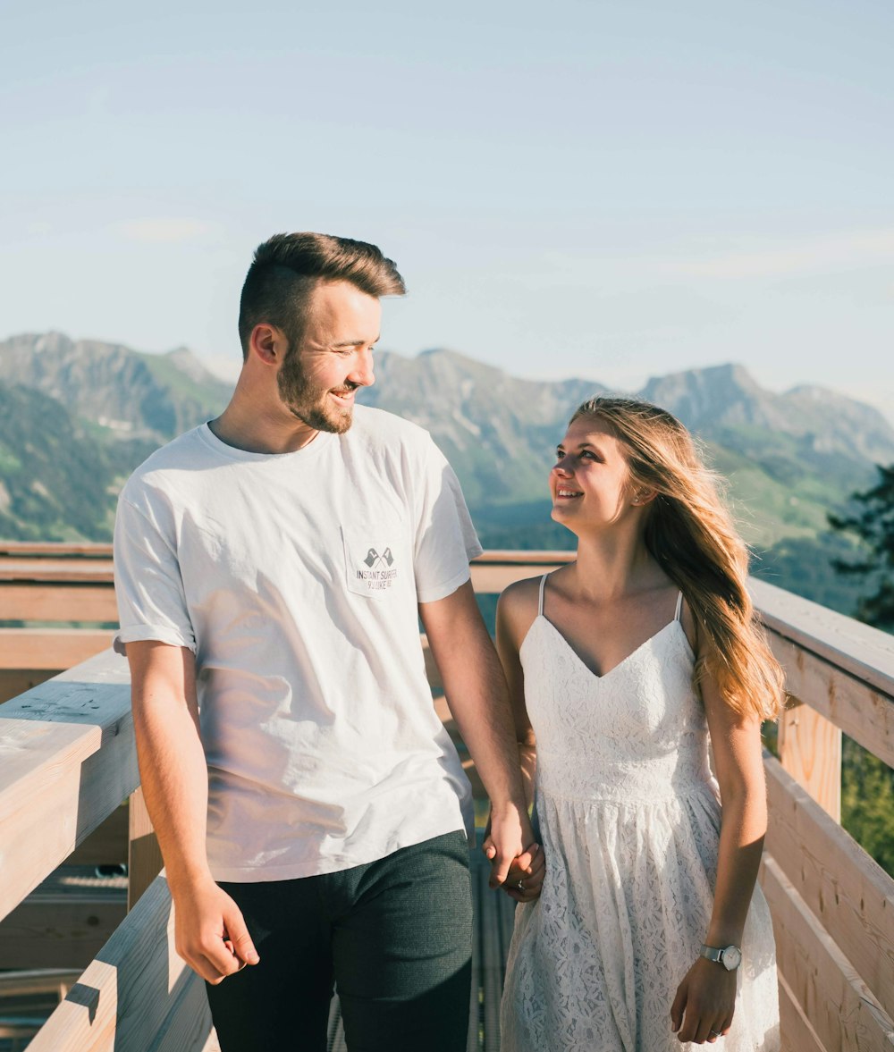 man in white crew neck t-shirt standing beside woman in white sleeveless shirt