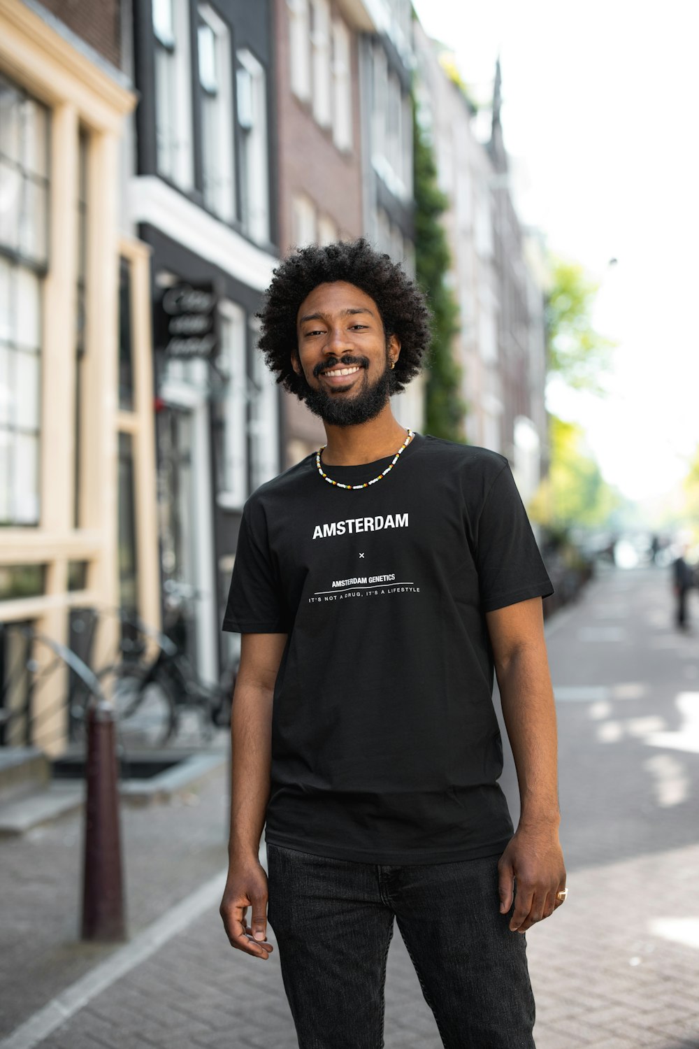 man in black crew neck t-shirt standing on street during daytime